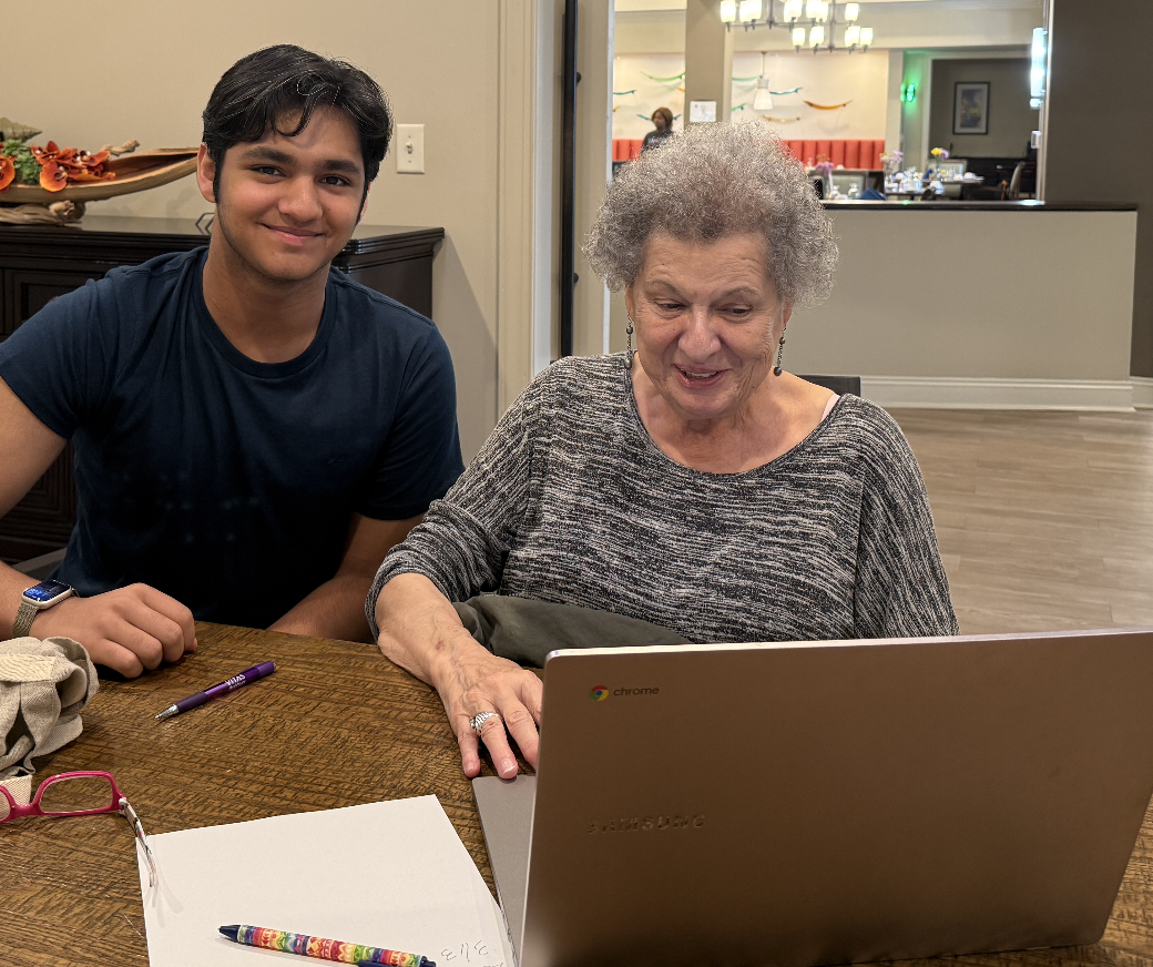 Ishaan guides a resident through her Chromebook
